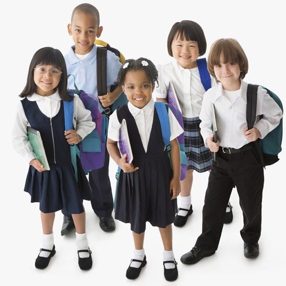Smiling students wearing school uniforms with backpacks