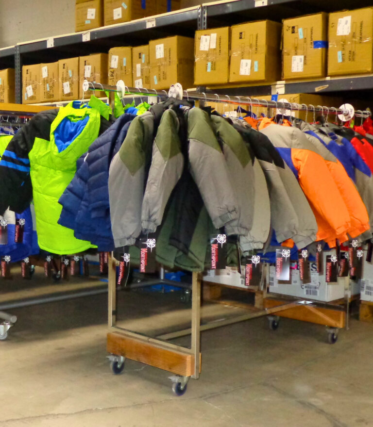 Racks of winter coats for school kids hanging in a warehouse